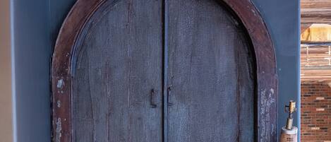 Una puerta doble de madera con un letrero encima que dice 'Restroom'.