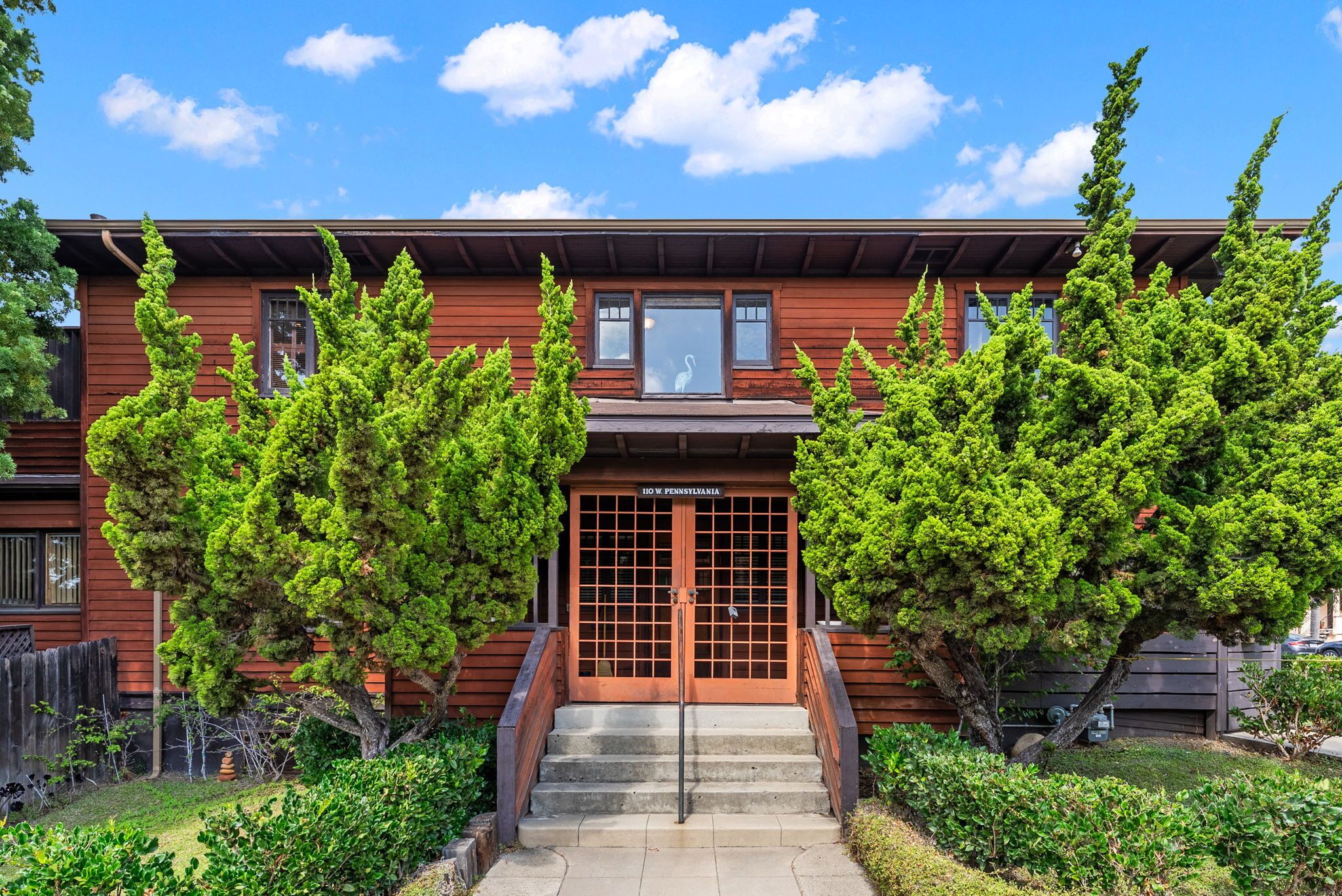 A two-story wooden house with a front entrance, a small porch, and a sign reading "10 W. Pennsylvania."