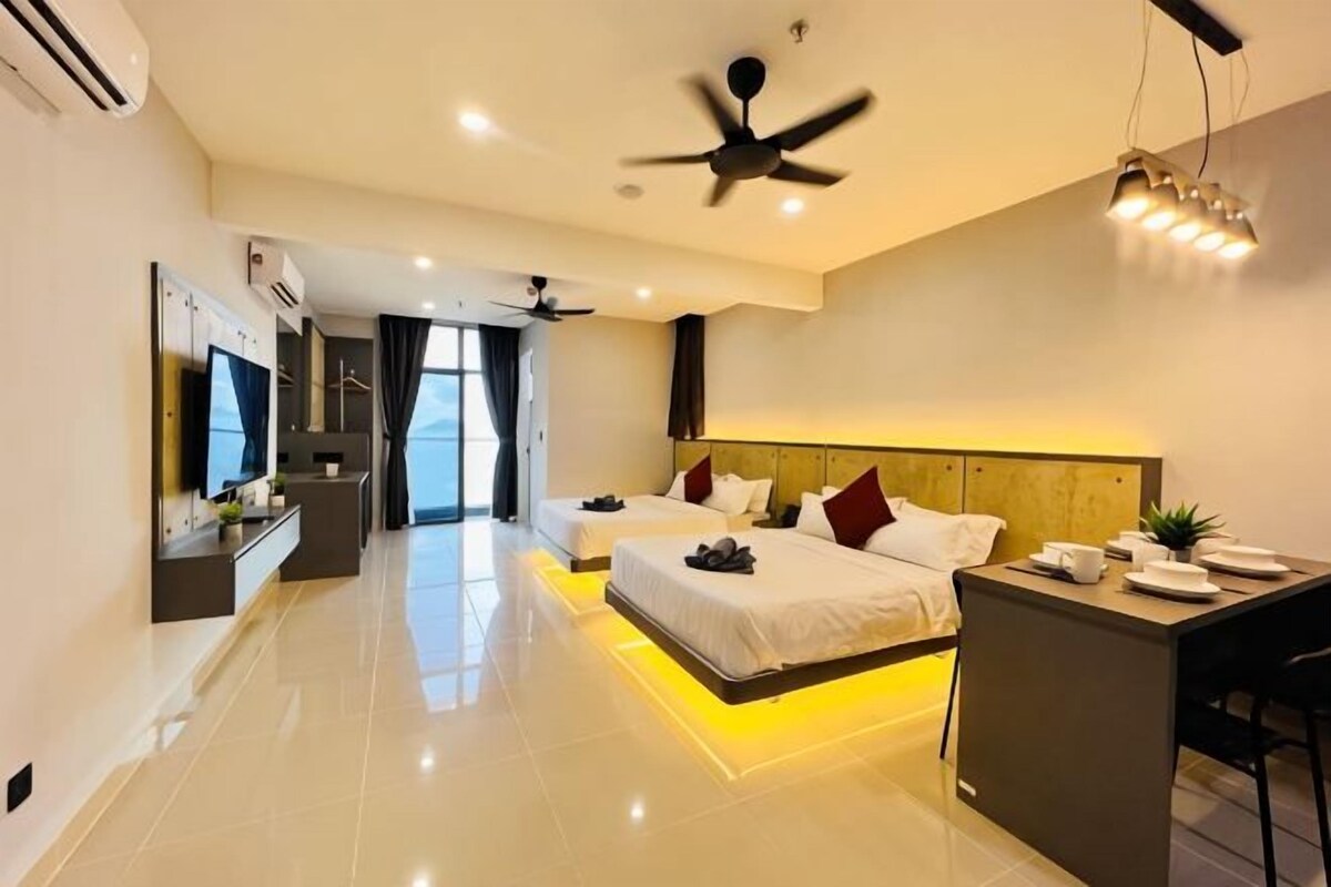 A modern hotel room with a bed, desk, and seating area.
