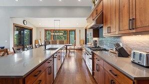 Una cucina moderna con mobili in legno, un'isola grande ed elettrodomestici in acciaio inossidabile.