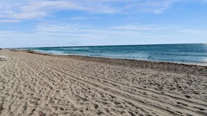 A sandy beach with visible tire tracks and a clear sky. - Hallandale Beach - 2 BR Luxury Condo (Hollywood)