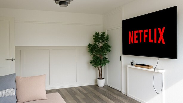 A modern living room with a large flat-screen TV mounted on the wall displaying "NETFLIX".