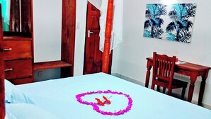 Ein Schlafzimmer mit einem Bett, einem Holztisch, einem Stuhl, einem Kleiderschrank und einer Tür.