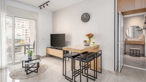 Un appartement moderne comprenant un coin repas, une cuisine et un espace de vie.