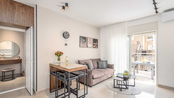 Un appartement moderne comprenant une cuisine, un coin repas, un canapé et un balcon.