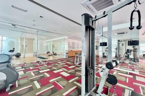 A gym with exercise equipment, a patterned carpet, and a glass wall reflecting the interior. - Lot 163 By ZenGlo (Kuala Lumpur)