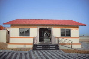 A building with a red roof, a reception area, and a staircase leading to the entrance. - Heritage Resort Dholavira (Dholavira)