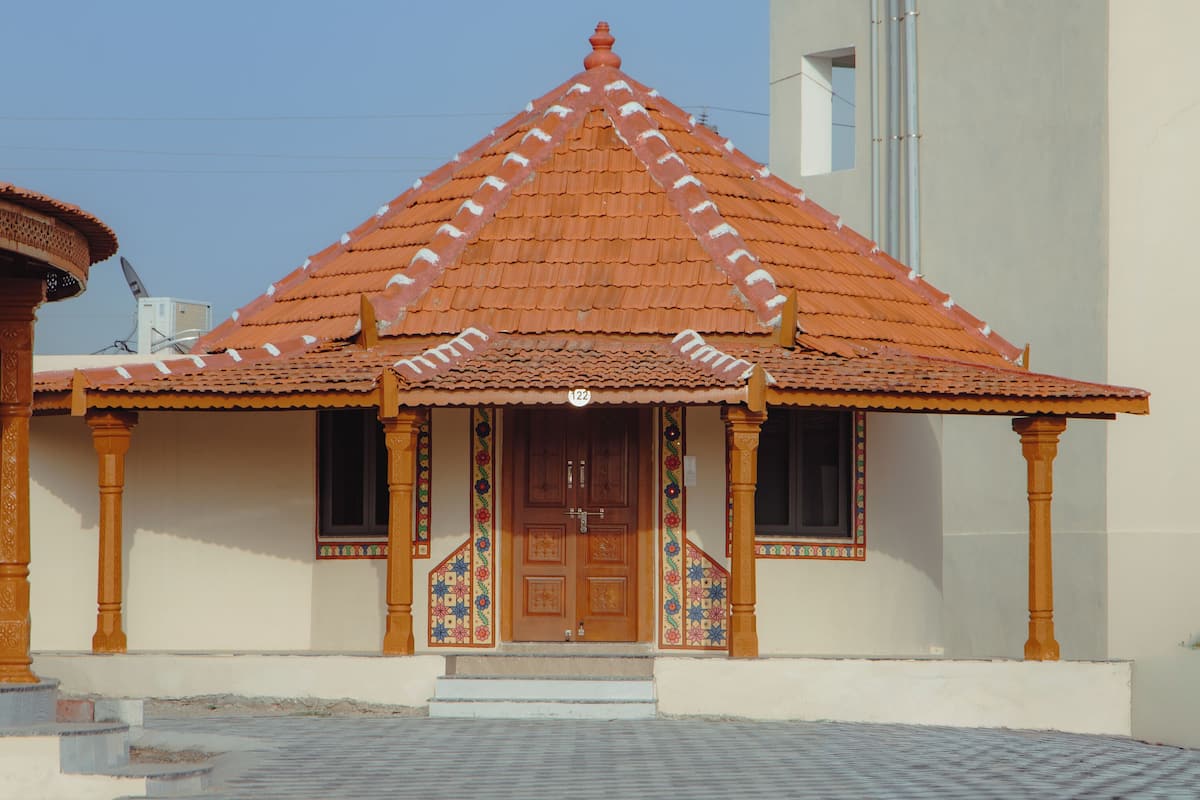 A traditional building with a tiled roof, a wooden door, and a small porch area.