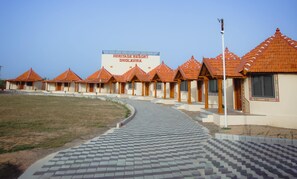 A row of traditional-style buildings with a sign reading "Heritage Resort Dhola Vira". - Heritage Resort Dholavira (Dholavira)
