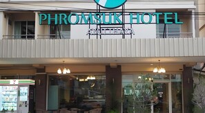 The exterior of Phromsuk Hotel with a signboard, entrance, and a vending machine. - Phromsuk Hotel Ayutthaya (Phra Nakhon Si Ayutthaya)