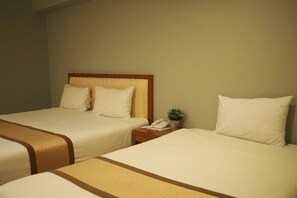 A hotel room with two beds, a bedside table with a telephone and a small plant, and a neutral-colored wall. - Phromsuk Hotel Ayutthaya (Phra Nakhon Si Ayutthaya)