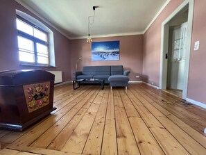 A living room with a sofa, a coffee table, a lamp, and a radiator.