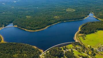 Ein weiter See, umgeben von dichten Wäldern, mit einer Brücke, die zwei Landstriche miteinander verbindet.