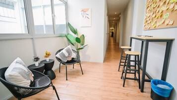 A hallway with a seating area, a table, and a wall with notes.
