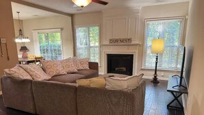 A cozy living room with a sectional sofa, a fireplace, and a sign that reads "OUR NEST". - Beautiful and cozy house in Duluth! (Duluth)