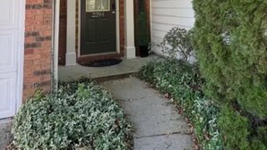 A two-story house with a brick facade, a front door with a number plate, and a small front yard with shrubs. - Beautiful and cozy house in Duluth! (Duluth)