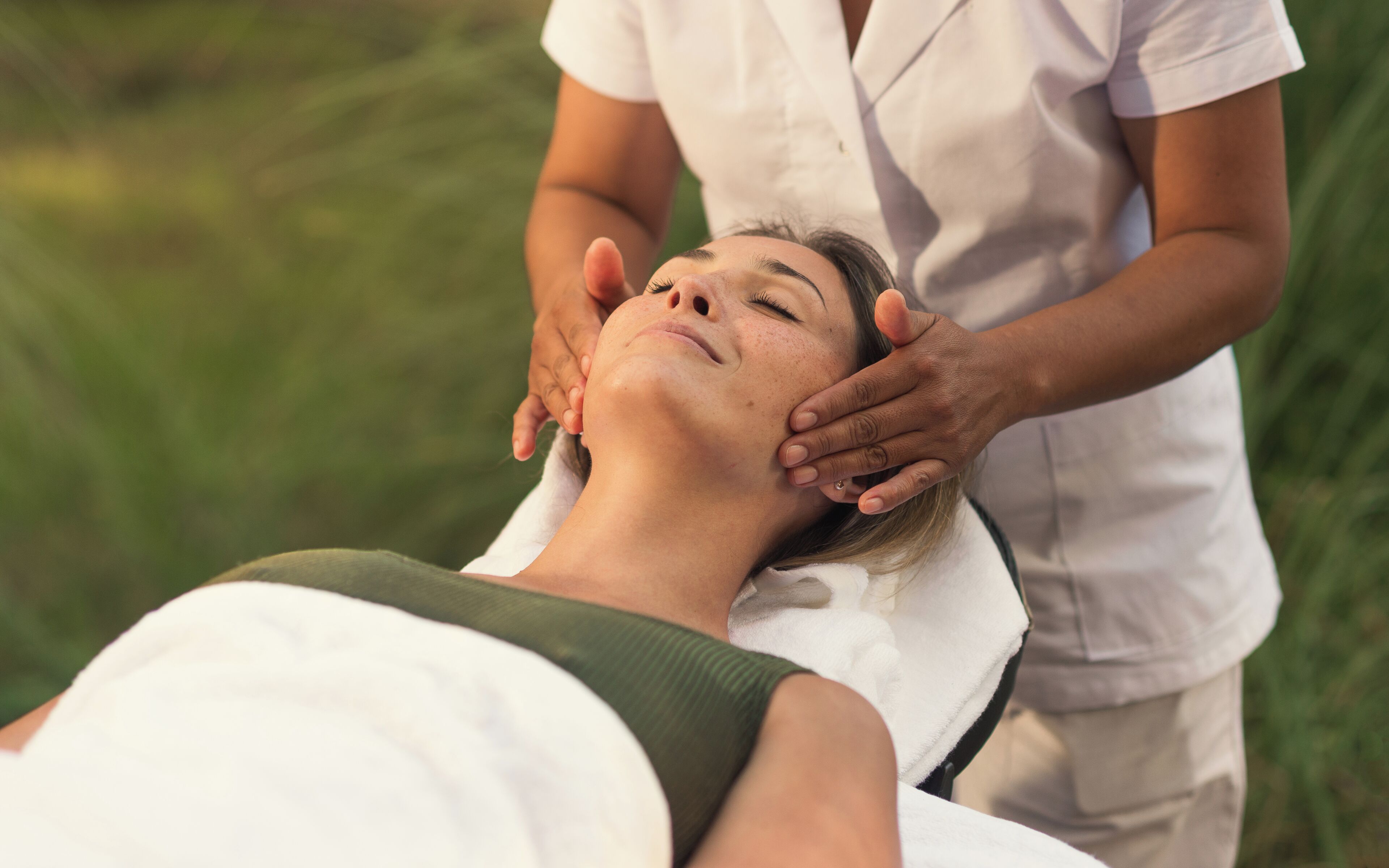A person receiving a massage in a room with a simple, uncluttered layout.
