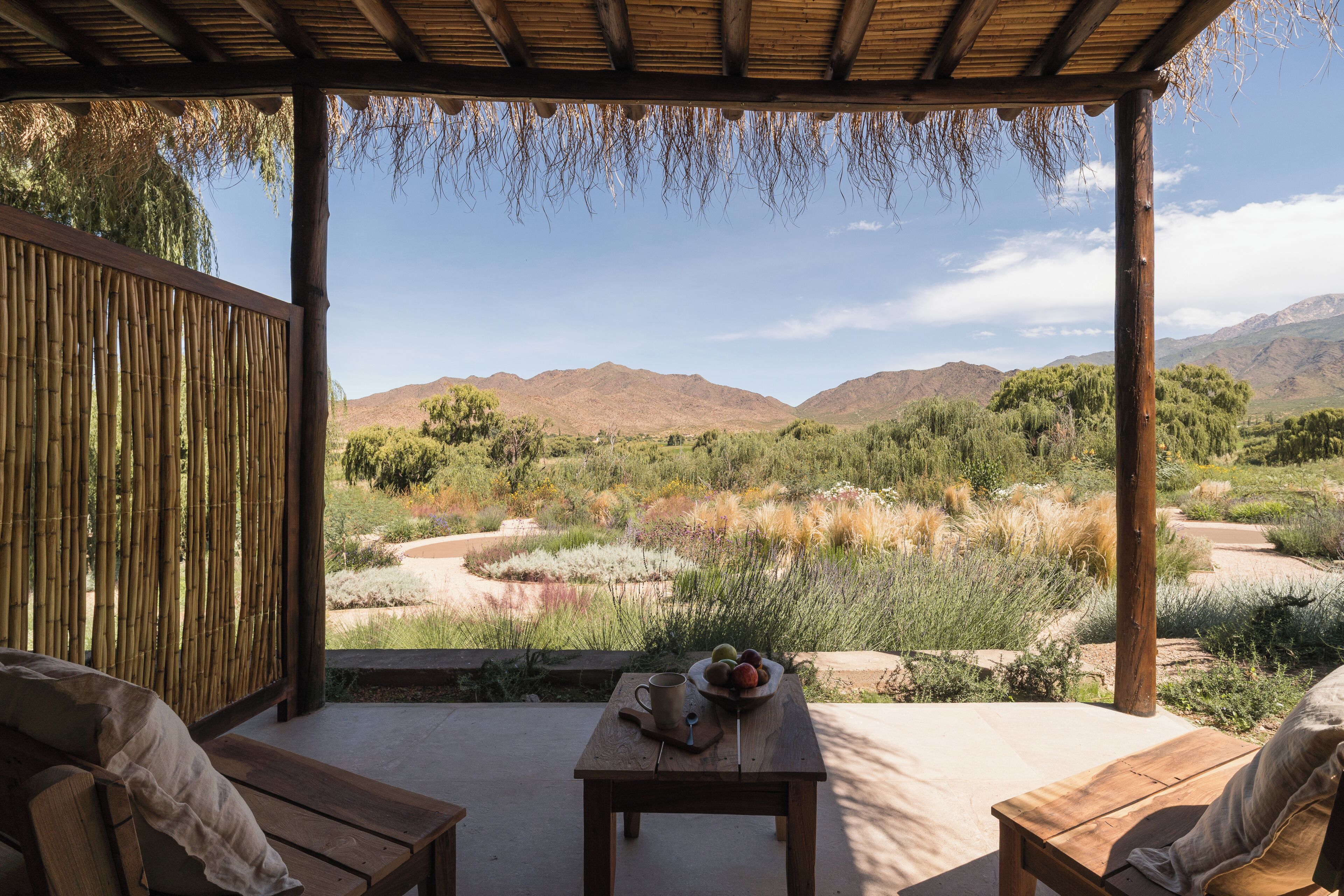 An outdoor seating area with a view of a river and mountains.