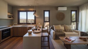 A modern kitchen with a dining area, a sofa, and a large window with a view. - Macal Cachi Luxury Lodge (Cachi)