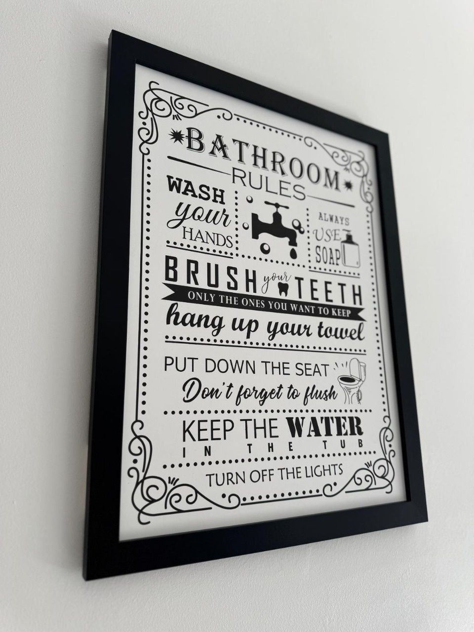 A framed bathroom rules sign with instructions like 'wash hands,' 'brush teeth,' and 'keep water in the tub.'