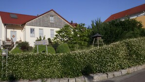 A building with a red roof, a wooden facade, and a sign in front. - "im Schiller" - Holiday Apartment in the Vineyards (Wiesenbronn)
