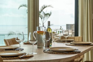 Een eettafel gedekt met borden, glazen en een karaf, met uitzicht op een prachtig landschap.