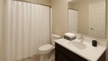 Een haardroger, handdoeken, zeep, toiletpapier