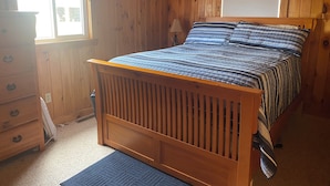A wooden bedroom with a bed, dresser, and window. - 3 Bedroom Lakefront home on Maidstone Lake (Maidstone)