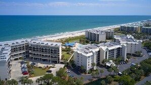 A coastal hotel with multiple buildings, a parking lot, and a beach view. - Short Easy Flat Walk to Beach - Pelican Watch 8a - Lakefront Villa w/ Pool (Pawleys Island)