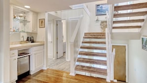 A kitchen with white cabinets, a built-in oven, and a countertop with a sink. - Short Easy Flat Walk to Beach - Pelican Watch 8a - Lakefront Villa w/ Pool (Pawleys Island)