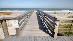 A wooden boardwalk leading to a beach with a sign indicating no flashlights from May to October. - Short Easy Flat Walk to Beach - Pelican Watch 8a - Lakefront Villa w/ Pool (Pawleys Island)