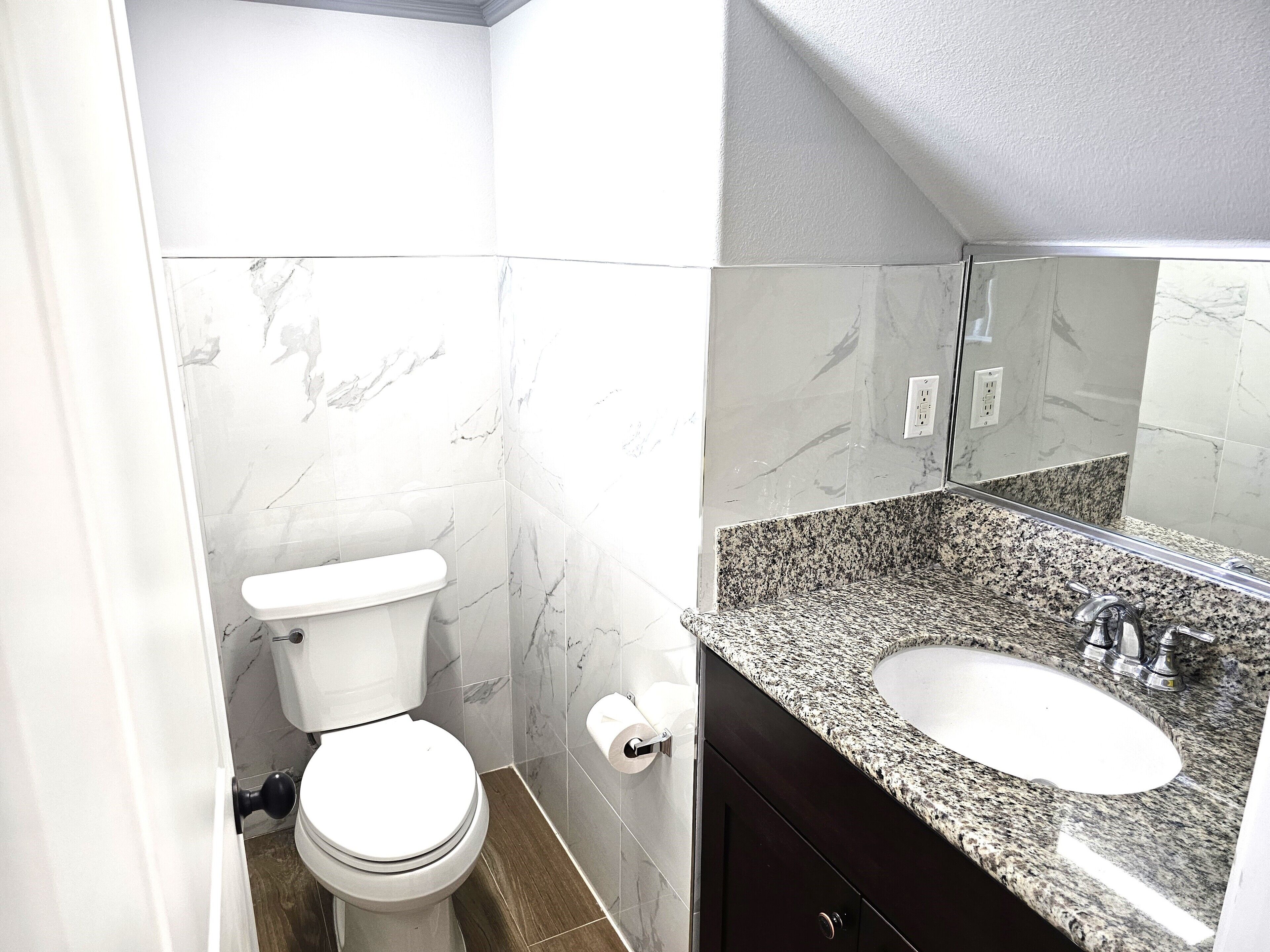 Un bagno con WC, lavandino e specchio.