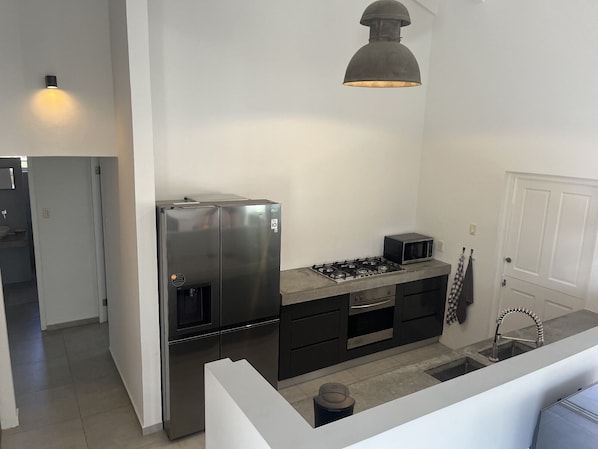 A modern kitchen with stainless steel appliances, a gas stove, and a microwave.