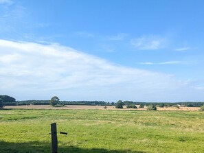 A rural landscape with open fields, a wooden post, and a distant building. - 6 Person Holiday Home in Gram (Gram)