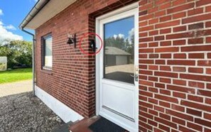 A brick building with a white door and a window.