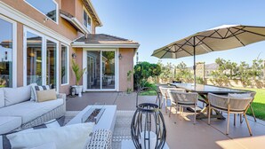 A patio with outdoor furniture, a table, and an umbrella. - Outdoor Oasis! Luxe Hilltop Home in San Marcos (San Marcos)