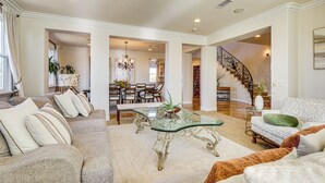 A spacious living room with a glass coffee table, a sofa, and a patterned armchair. - Outdoor Oasis! Luxe Hilltop Home in San Marcos (San Marcos)