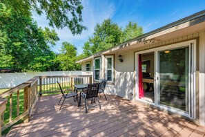 A covered deck with a table and chairs, a sliding glass door, and a white fence. - Walk to Campus, FSU Photo Wall: Inviting Retreat! (Tallahassee)