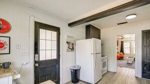 A kitchen with a refrigerator, a trash can, and a coffee sign. - Time Machine: Games Galore in Lubbock Home By TTU! (Lubbock)