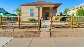Una casa a due piani con un portico, un ingresso e un piccolo giardino antistante.