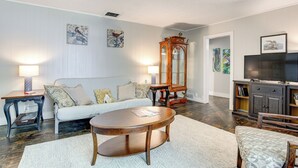 Ein Wohnzimmer mit Sofa, Couchtisch und TV-Schrank.