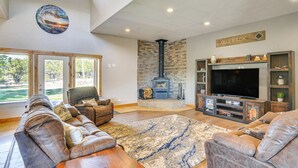 A spacious living room with leather sofas, a large TV, a fireplace, and a sign that says "OUT BACK". - Beautiful 4 bedroom mountain retreat , with stunning views. (Buena Vista)