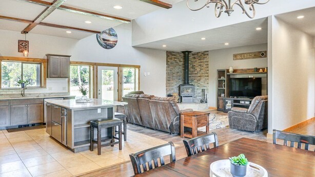 A spacious living area with a fireplace, a dining table, and a kitchen with a large island. - Beautiful 4 bedroom mountain retreat , with stunning views. (Buena Vista)
