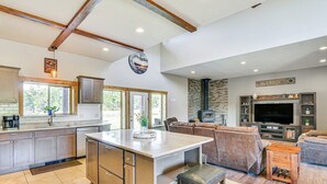 A spacious kitchen with a large island, a dining area with a sofa, and a living room with a TV and fireplace. - Beautiful 4 bedroom mountain retreat , with stunning views. (Buena Vista)