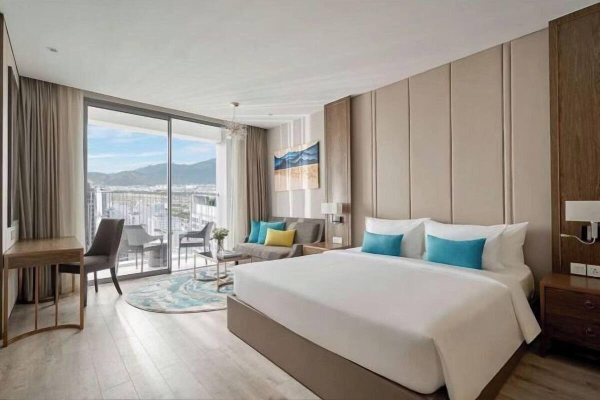 Una camera d'albergo moderna con un letto grande, una scrivania e vista sulla città.