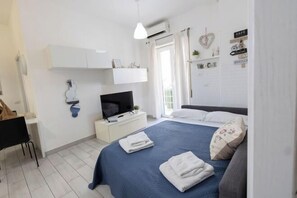 A bedroom with a bed, a TV, a desk, and a wardrobe. - Nicla's Home (Rome)