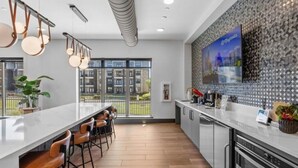 Una cucina moderna con un piano di lavoro in marmo, elettrodomestici in acciaio inox e un'ampia finestra con vista sulla città.