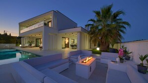 A modern two-story house with a swimming pool, outdoor seating, and a fire pit. - Villa LUMINOSA with outdoor and indoor pool and sauna (Vrh)