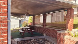 Un patio cubierto con una mesa de picnic y un tapete decorativo.