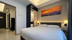 Een hotelkamer met een groot bed, een schilderij van een zonsondergang en twee bedlampen.